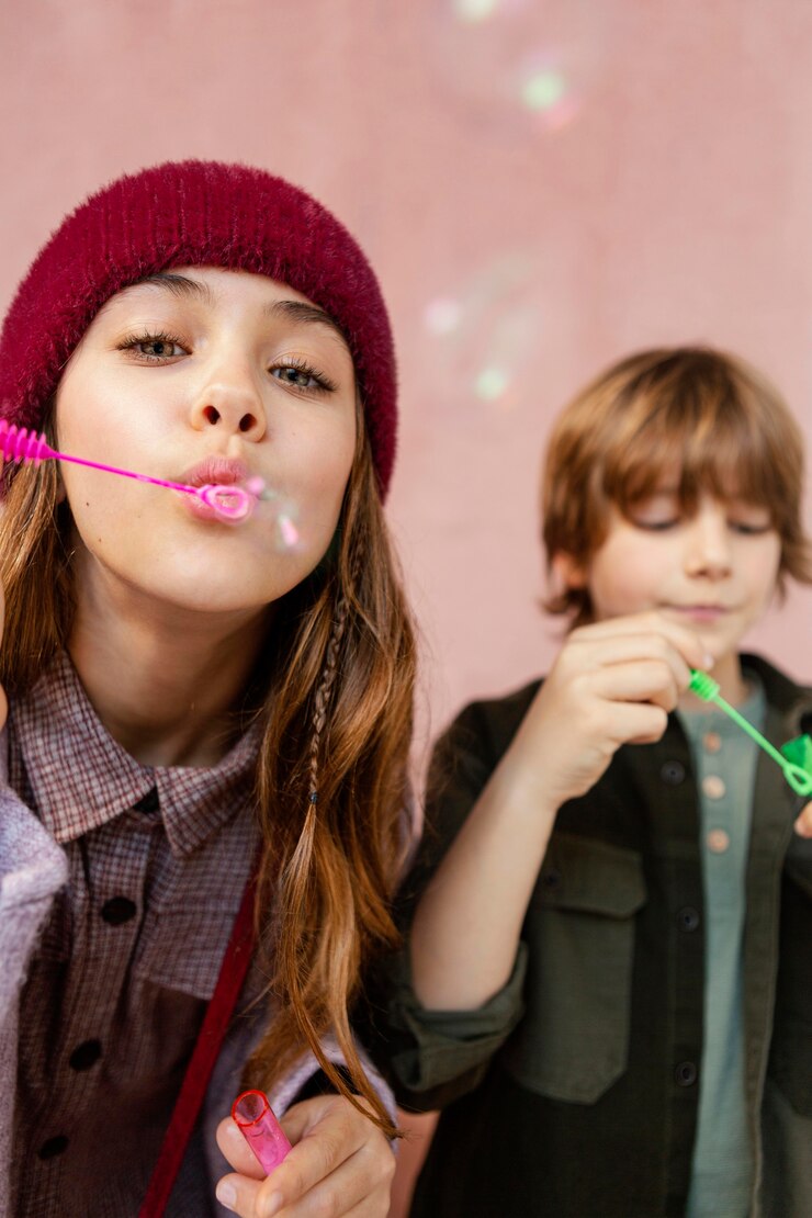 Foto grátis menino e menina brincando com bolhas de sabão