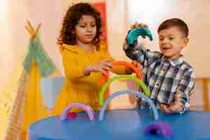 Foto grátis menino e menina brincando dentro de casa com brinquedos ecológicos