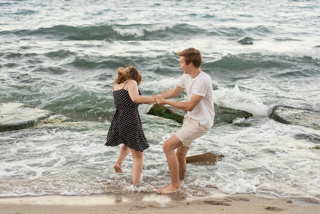 Menino e menina brincando juntos no mar