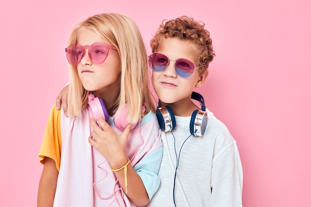 Menino e menina na moda em óculos de sol se divertem com amigos, moda infantil casual