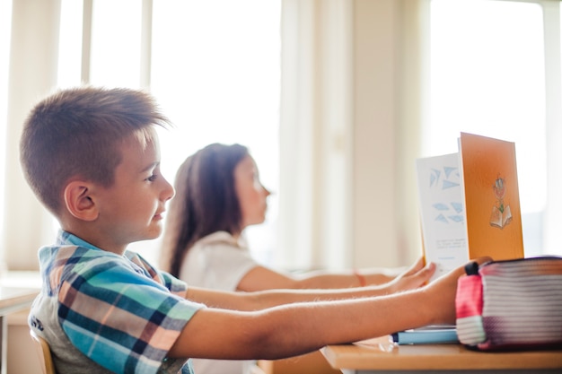 Menino e menina sentados na sala de aula