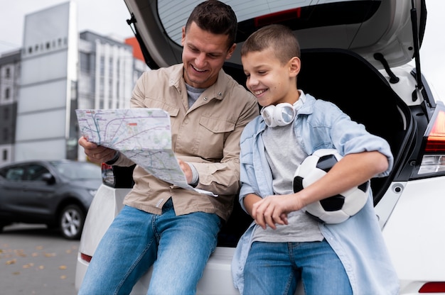 Menino e pai perto de um carro elétrico