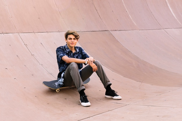 Foto grátis menino elegante sentado no skate