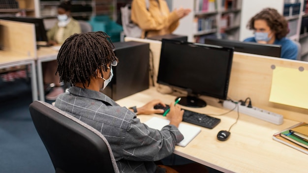 Menino estudando pacificamente na biblioteca