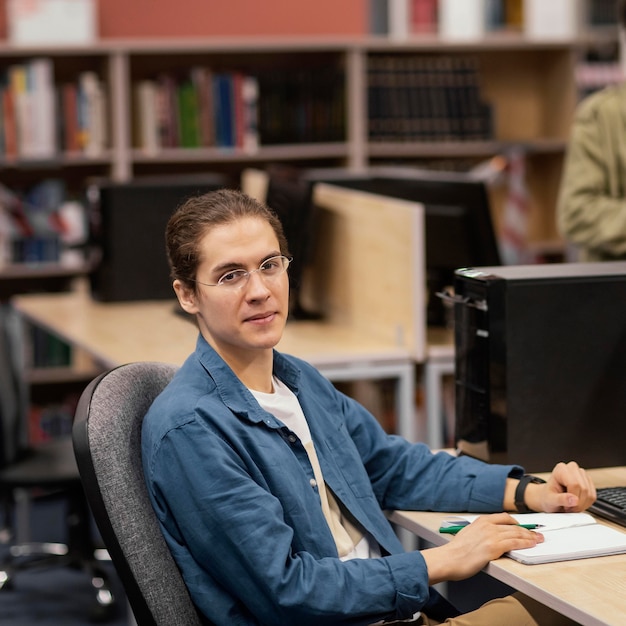 Menino estudando pacificamente na biblioteca