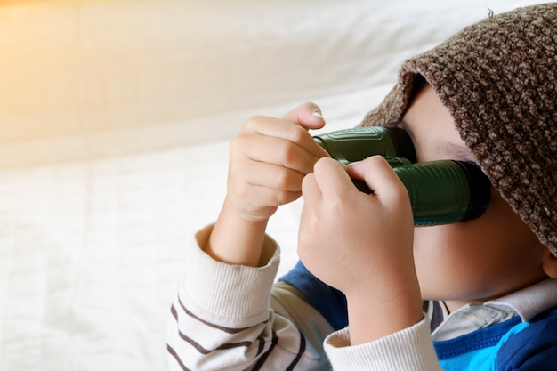 Menino feliz brincando com avião de brinquedo, pequeno garoto asiático goza de viagem, conceito de viagem e aventura