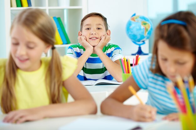 Menino feliz com os amigos estudando