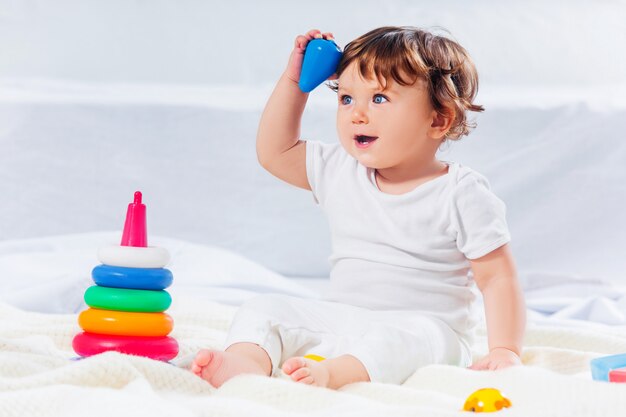 Menino feliz, sentado com brinquedo