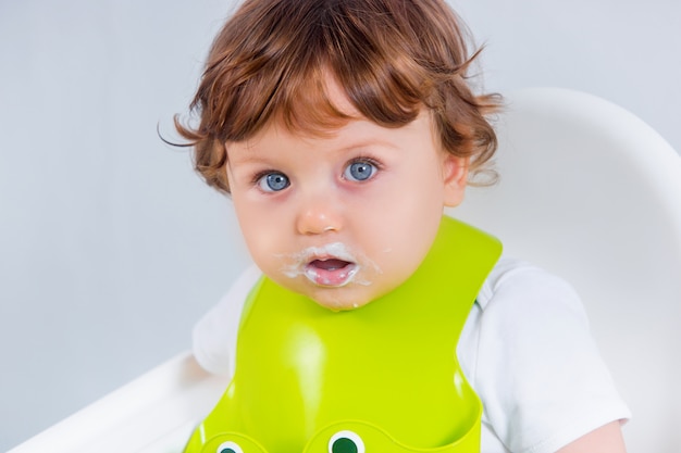 Menino feliz sentado e comendo