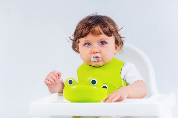 Menino feliz sentado e comendo