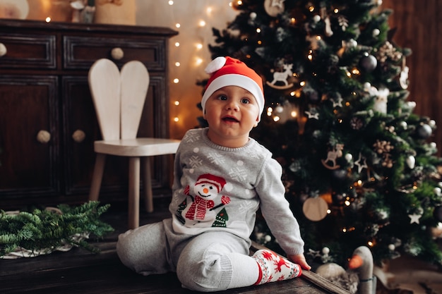 Menino fofo com chapéu de Papai Noel.