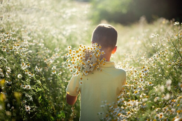 Lindas flores na mÃ£o da crianÃ§a no campo de flor | Foto Premium