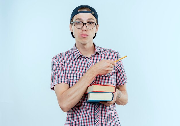 menino jovem estudante usando óculos e boné segurando livros e pontas ao lado com uma caneta