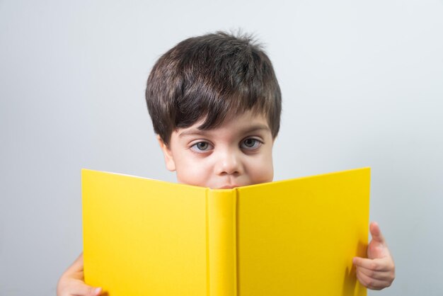 Menino lendo livro amarelo