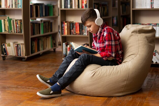 Foto grátis menino na leitura do sofá