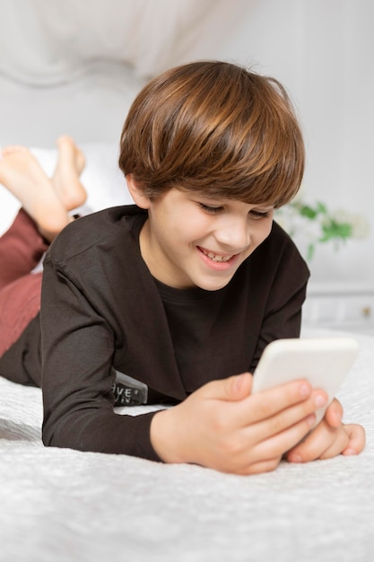 Menino no quarto com telefone