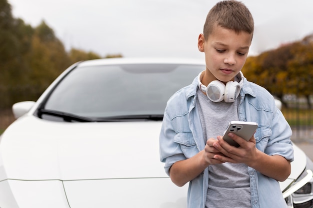 Foto grátis menino perto de um carro elétrico