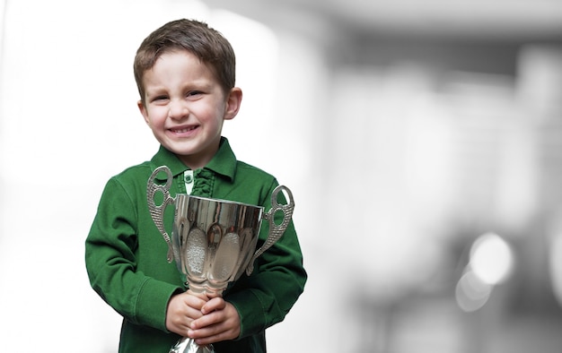 Menino que prende um troféu