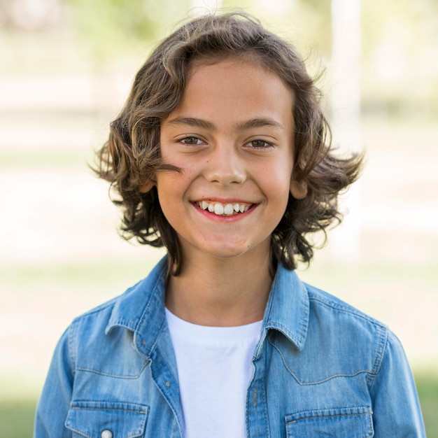 Menino sorridente a posar no parque