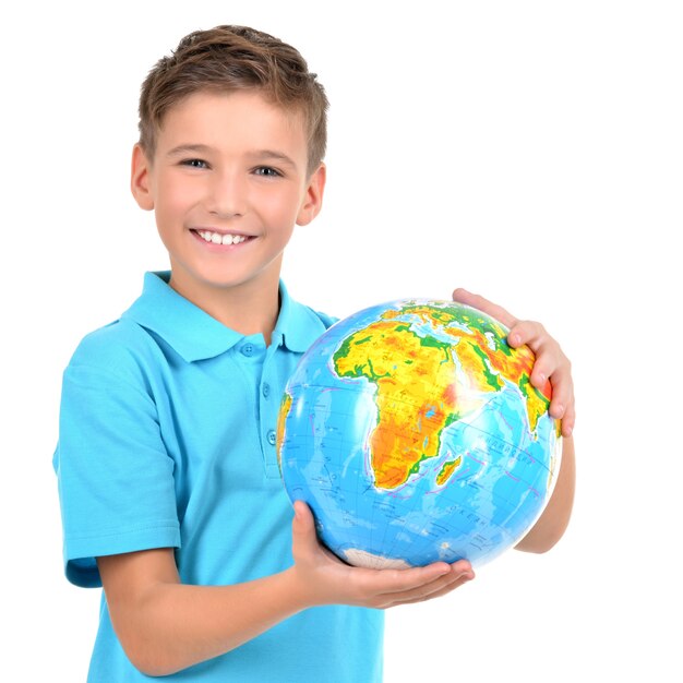 Menino sorridente casual segurando o globo nas mãos - isolado no branco