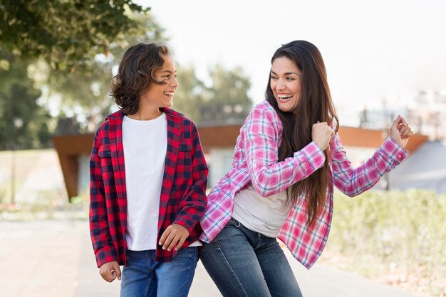 Menino sorridente e mãe brincando juntos ao ar livre