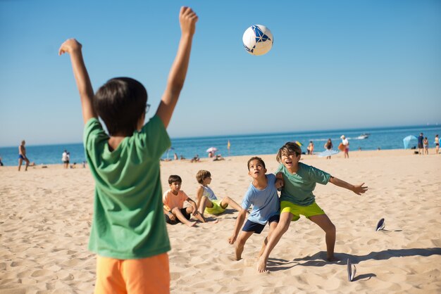 Meninos lutando pela bola ao jogar futebol