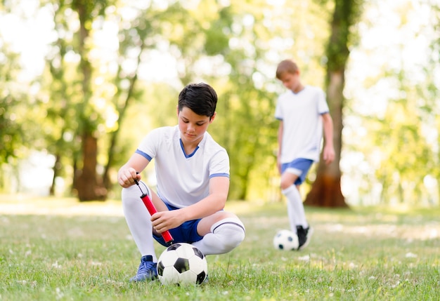 Foto grátis meninos treinando para uma partida de futebol ao ar livre