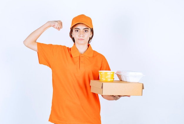 Mensageira com uniforme laranja segurando amarelo