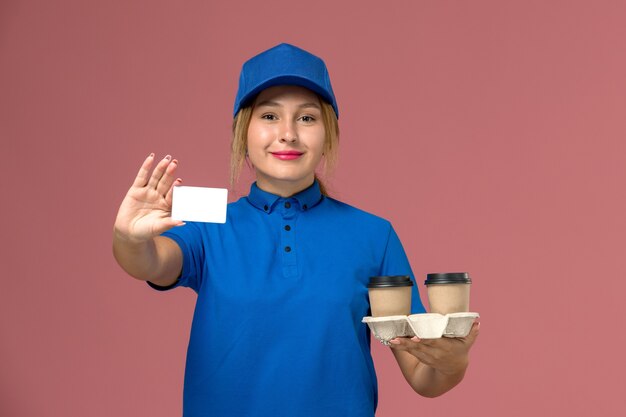 mensageira de uniforme azul segurando xícaras de café e um cartão branco rosa, trabalhador de entrega de uniforme de serviço