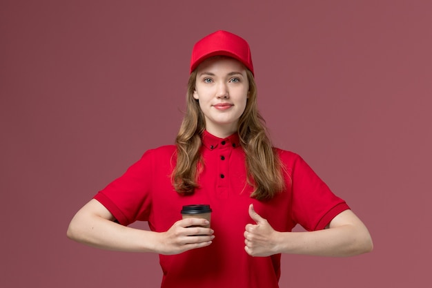 mensageira de uniforme vermelho segurando a xícara de café de entrega com um sorriso rosa, uniforme de trabalho.