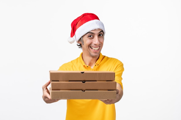 Mensageiro frontal masculino com caixas de pizza na entrega de serviço uniforme de parede branca