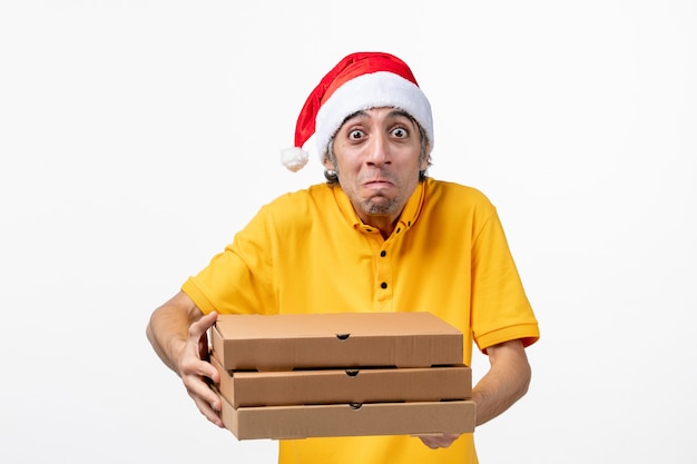 Mensageiro frontal masculino com caixas de pizza no uniforme de serviço de trabalho de parede branca ano novo