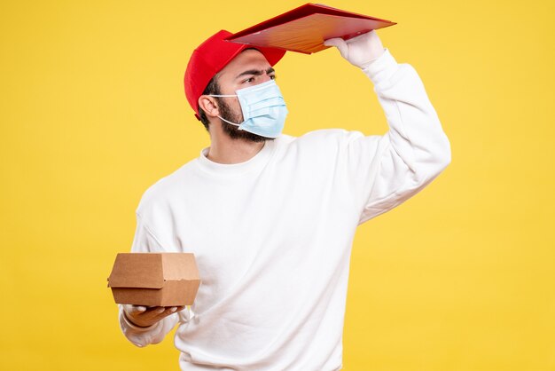 mensageiro masculino com máscara segurando uma nota de arquivo em amarelo