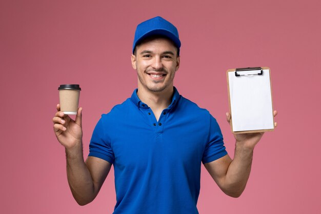 Mensageiro masculino de uniforme azul segurando uma xícara de café marrom com bloco de notas rosa, uniforme de trabalhador.