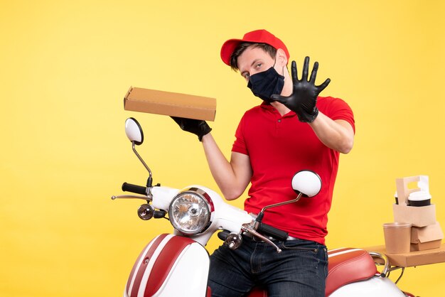 Mensageiro masculino de vista frontal em bicicleta com máscara e caixa de comida em amarelo