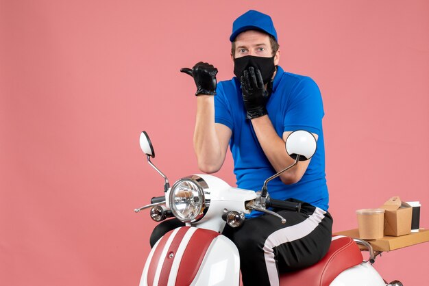 Mensageiro masculino de vista frontal em uniforme azul e máscara em comida rosa trabalho fast-food serviço entrega bicicleta vírus trabalho covid-