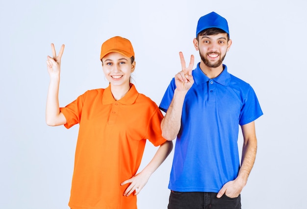 Mensageiro menino e menina em uniformes azuis e amarelos, mostrando sinal de prazer e felicidade.