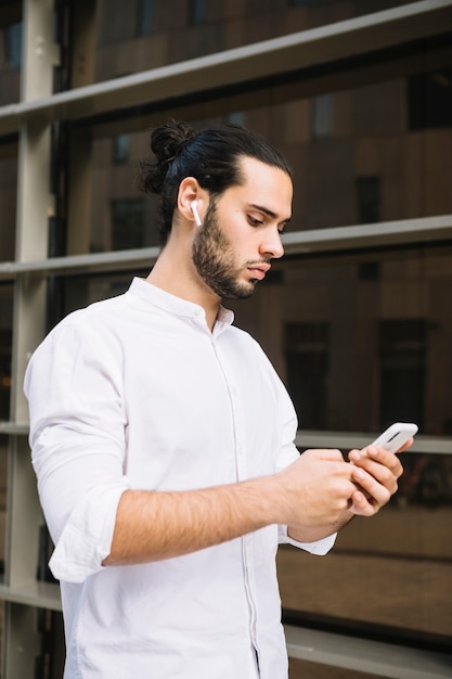 Foto grátis mensagem de mensagens de texto elegante empresário no smartphone no exterior