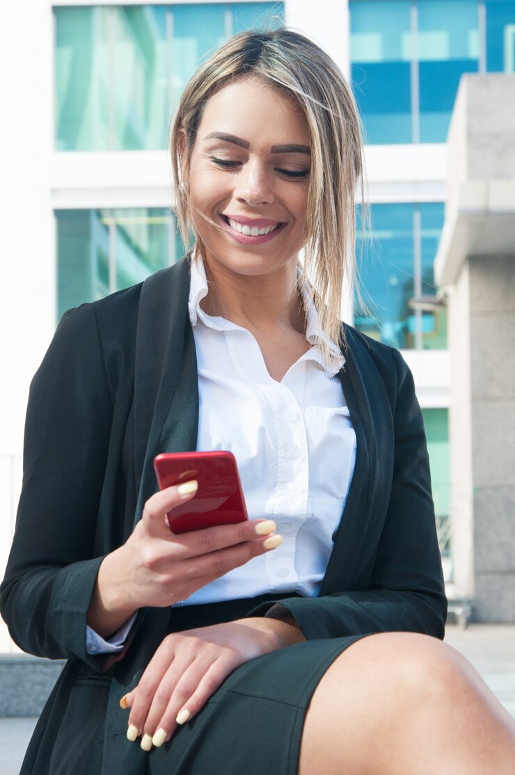 Foto grátis mensagens de empresária alegre no telefone ao ar livre
