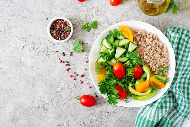 Menu de dieta. Salada vegetariana saudável de legumes frescos - tomate, pepino, pimentos e mingau na tigela. Comida vegana. Postura plana. Vista do topo