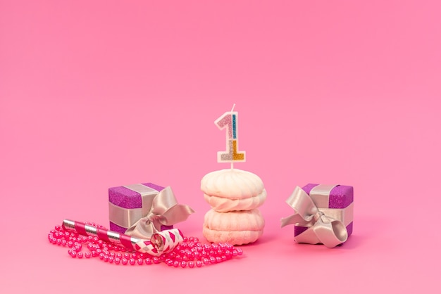 Merengues de vista frontal e caixas em rosa, bolo de aniversário