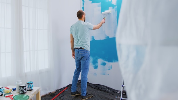 Foto grátis mergulhando a escova de rolo na tinta. renovação de casa, renovação de faz-tudo. redecoração de apartamento e construção de casa durante a reforma e melhoria. reparação e decoração.