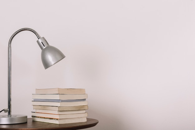 Mesa com lâmpada e livros