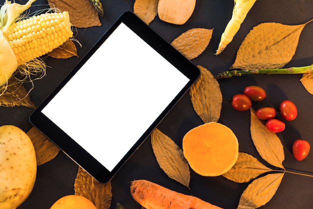 Mesa com legumes e tablet