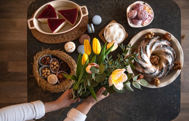 Mesa de café da manhã ou brunch repleta de ingredientes saudáveis para uma deliciosa refeição de Páscoa com amigos e familiares ao redor da mesa. O conceito de férias da Páscoa e os valores familiares.