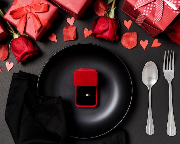 Mesa de dia dos namorados posta com anel de noivado no prato e rosas