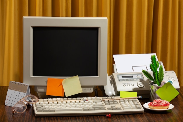 Mesa de escritório bagunçada com computador antigo ainda vida