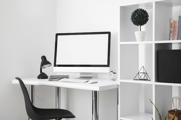 Mesa de escritório com tela de computador e cadeira