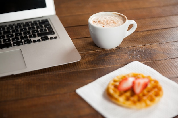 Foto grátis mesa de escritório com uma chávena de café e portátil