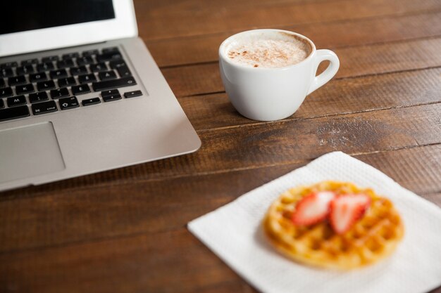 mesa de escritório com uma chávena de café e portátil